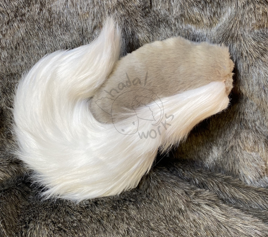 A husky-style tail with short gray fur on top and long white fur on the bottom