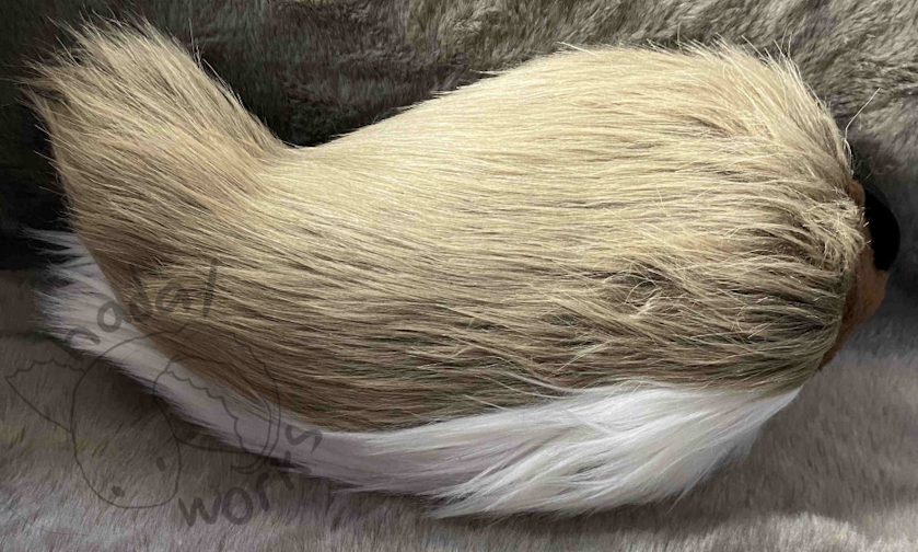 Short stumpy fursuit tail with a brown top and white underside.